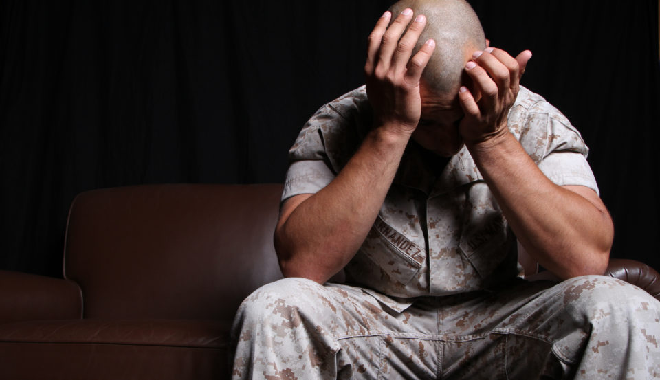 Veteran with PTSD sitting with his head in his hands